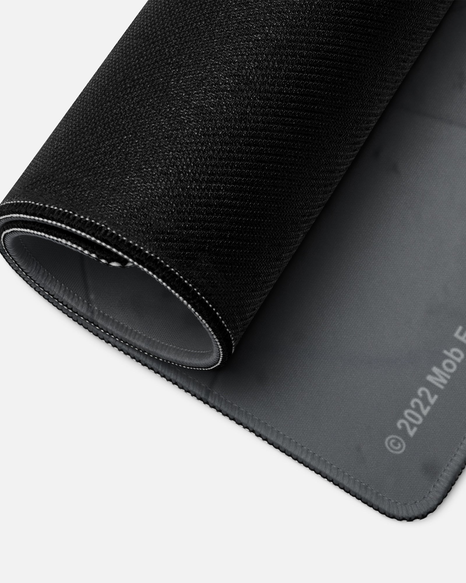 smiling huggy wuggy gamer mousepad rolled up to show bottom material.