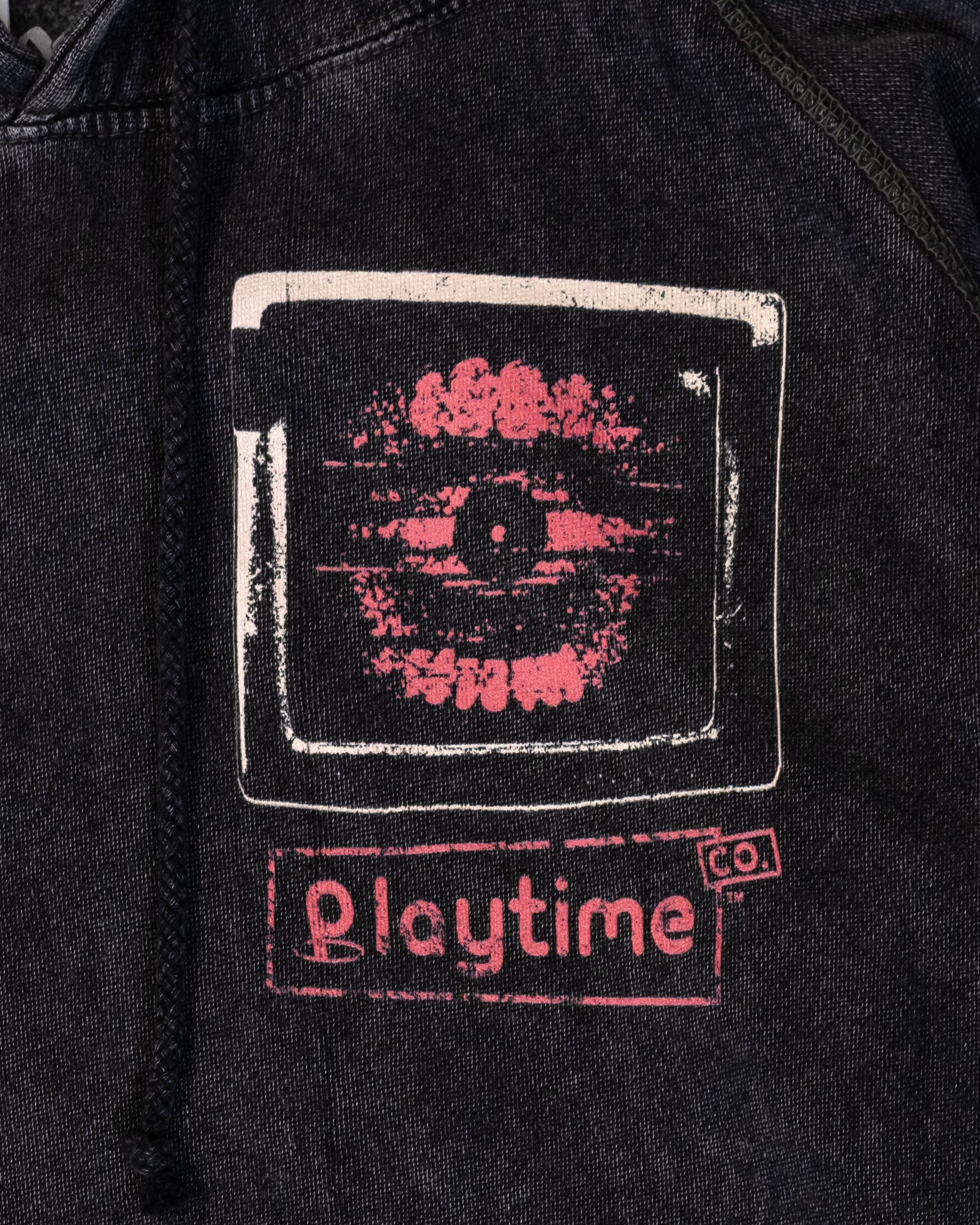 image on front of hoodie: teeth with eye ball inside mouth on TV screen. text: playtime co.