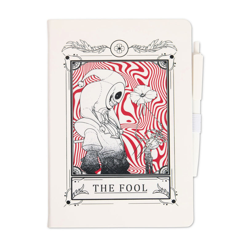 White journal with attached white pen featuring a tarot-style illustration titled “The Fool,” showing The Prototype holding a flower against a red swirling background.