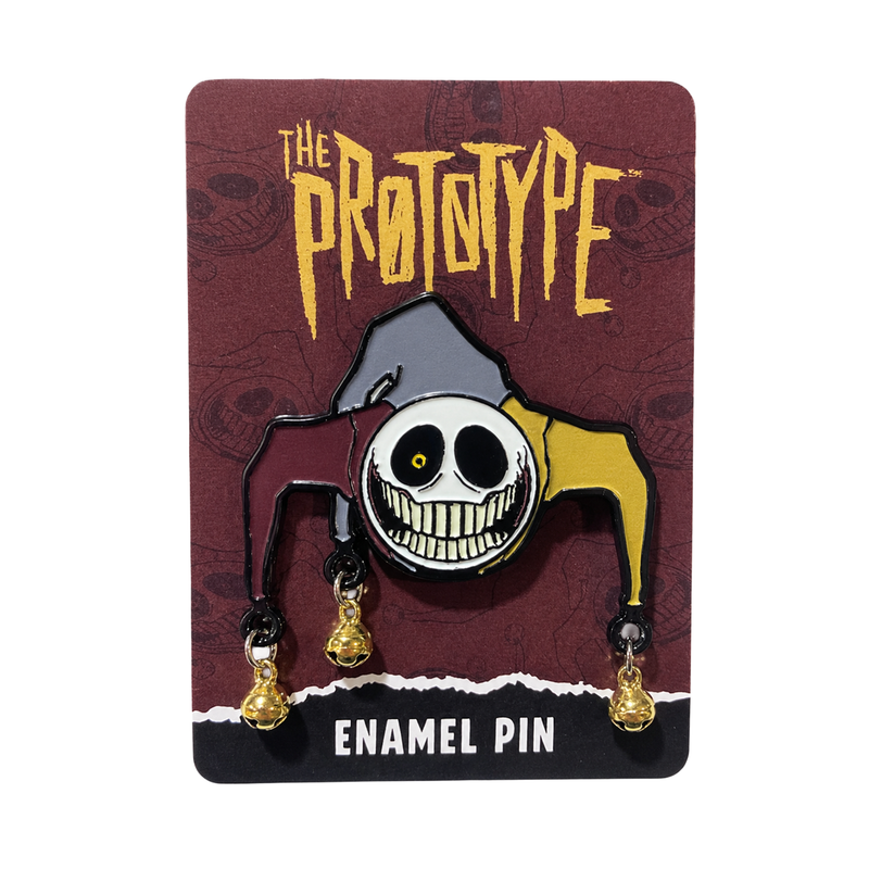 A Prototype-themed enamel pin featuring a stylized clown face with dangling gold bells, mounted on a dark brown backing card printed with the 'The Prototype' logo and 'Enamel Pin' text.