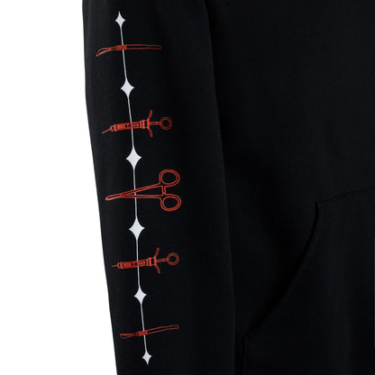 A close-up of a black sweatshirt sleeve featuring a vertical black line of surgical instrument.