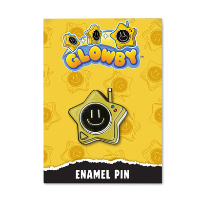 A yellow Glowby enamel pin card featuring a star-shaped pin with a black smiley face. The card has the Glowby logo at the top and at the bottom that reads 'ENAMEL PIN'.