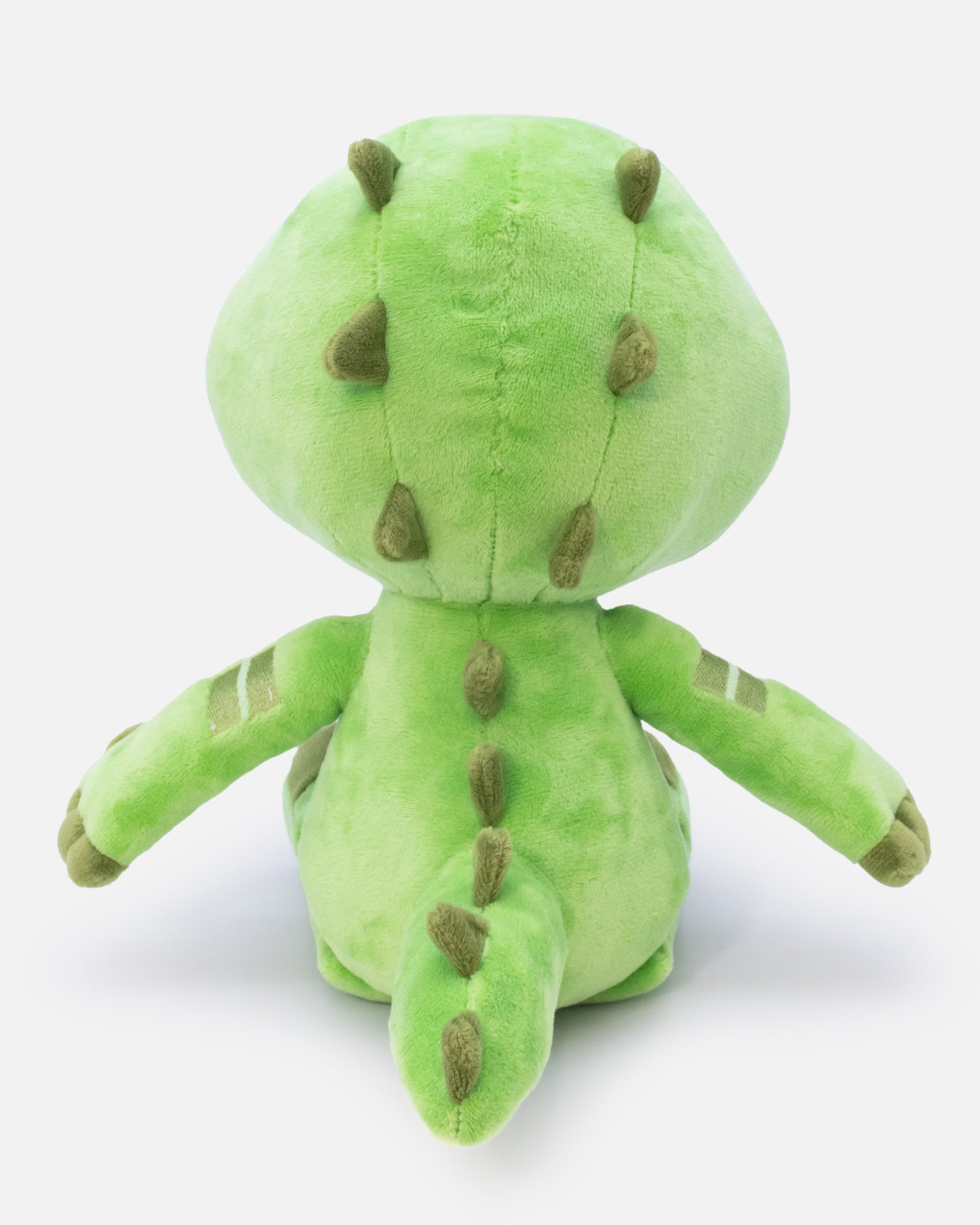 Green plush toy with brown spots on a white background