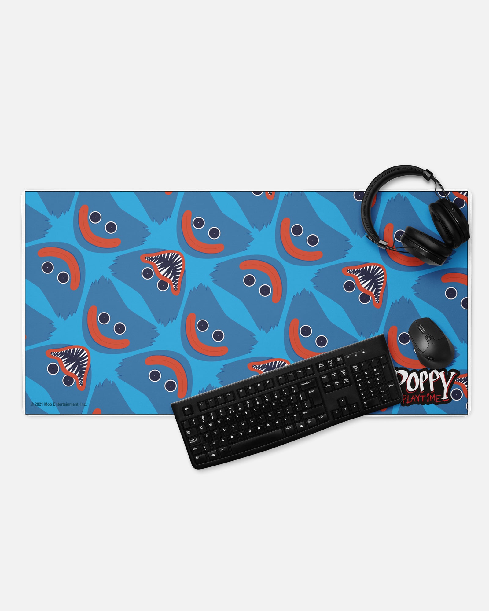 huggy wuggy gamer mousepad with headphones, keyboard, and mouse to show example of gaming set up. image: repeating pattern of evil and good huggy faces. text: poppy playtime