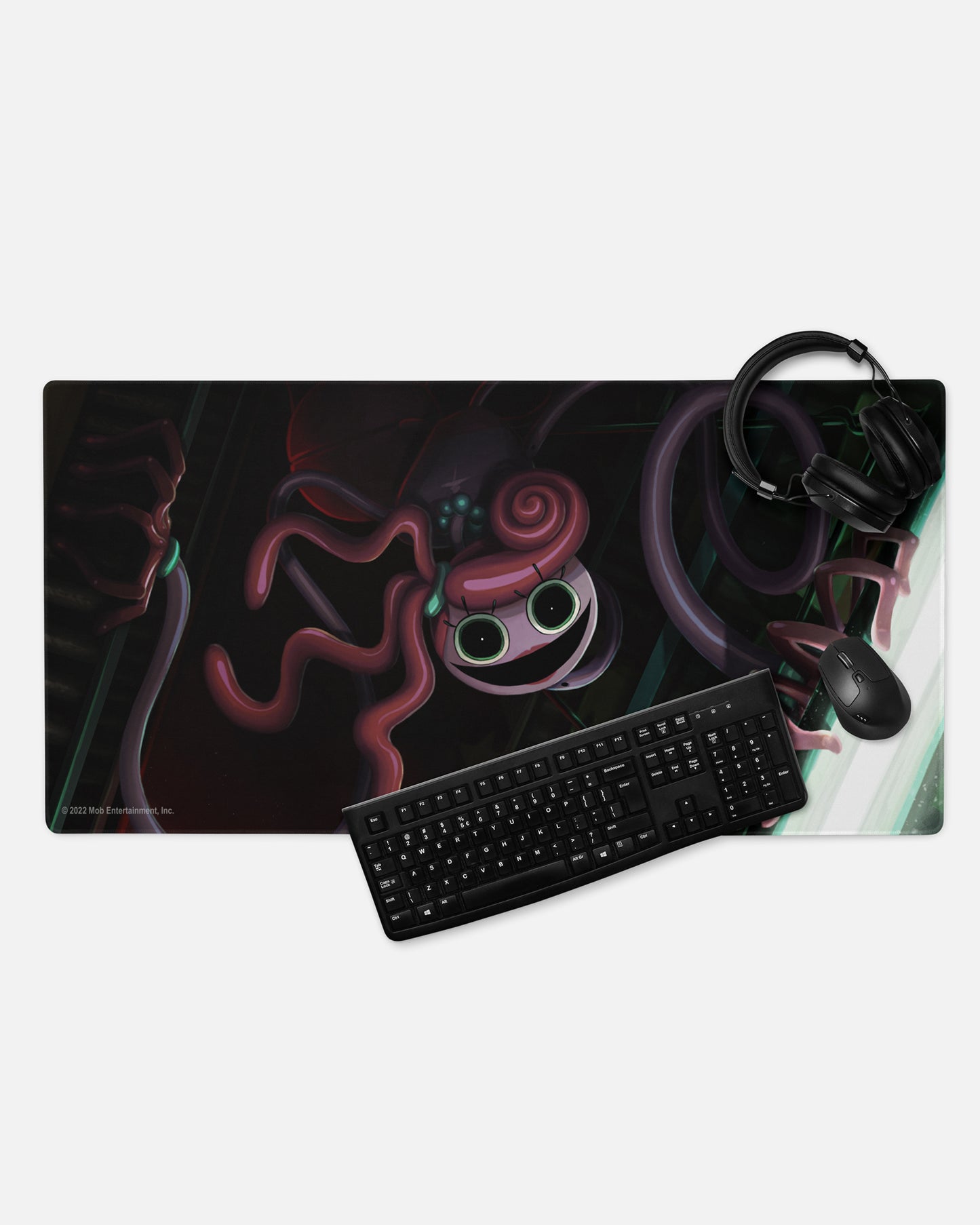 mommy longlegs gamer mousepad with headphones, keyboard, and mouse to show example of gaming set up. image: scary mommy longlegs crawling down grabbing light.