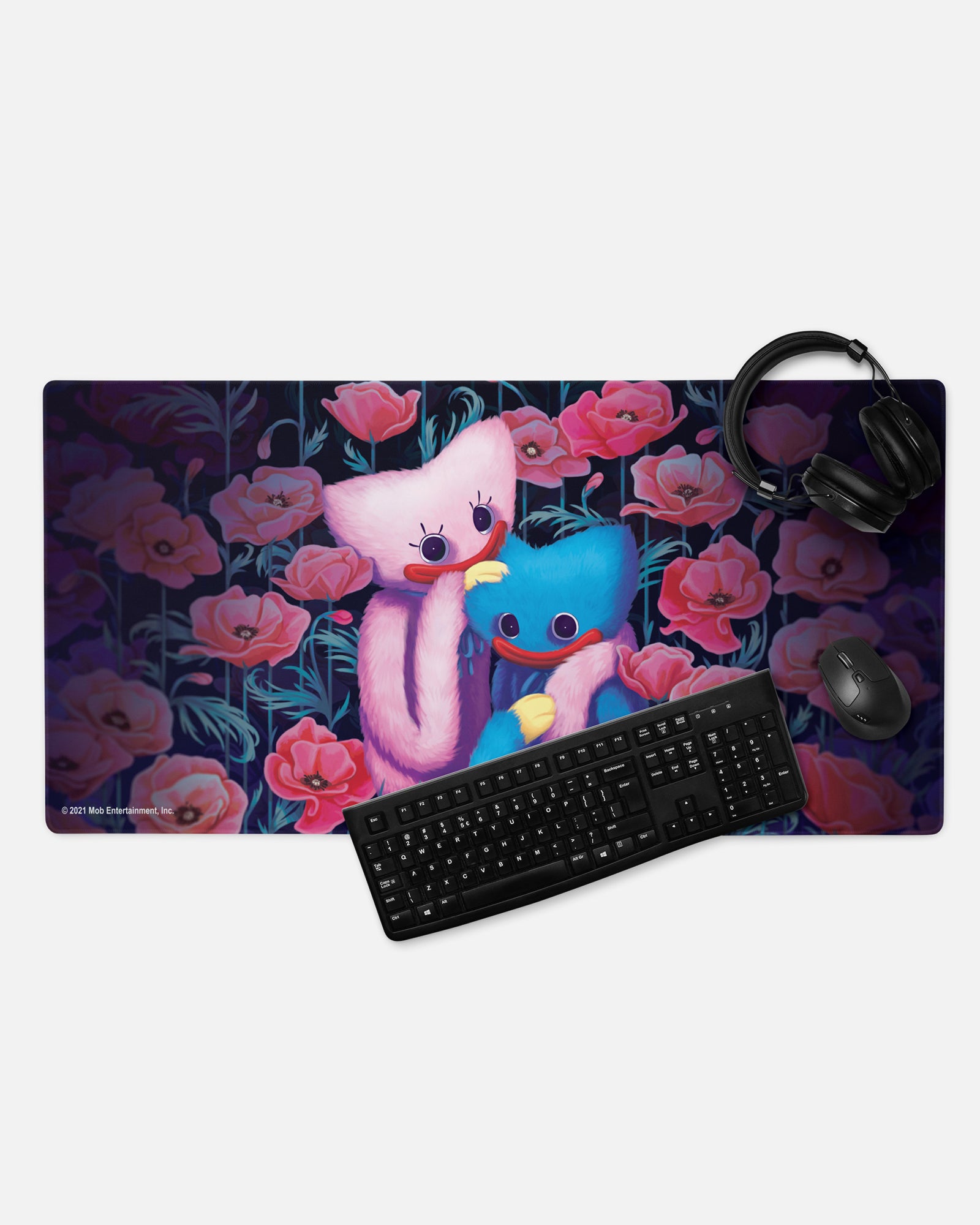 kissy missy huggy wuggy gamer mousepad with headphones, keyboard, and mouse to show example of gaming set up. image: kissy missy and huggy wuggy holding each other in a field of poppy flowers